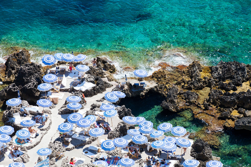 La fontelina beach Capri an Italian beach with blue and white umbrellas