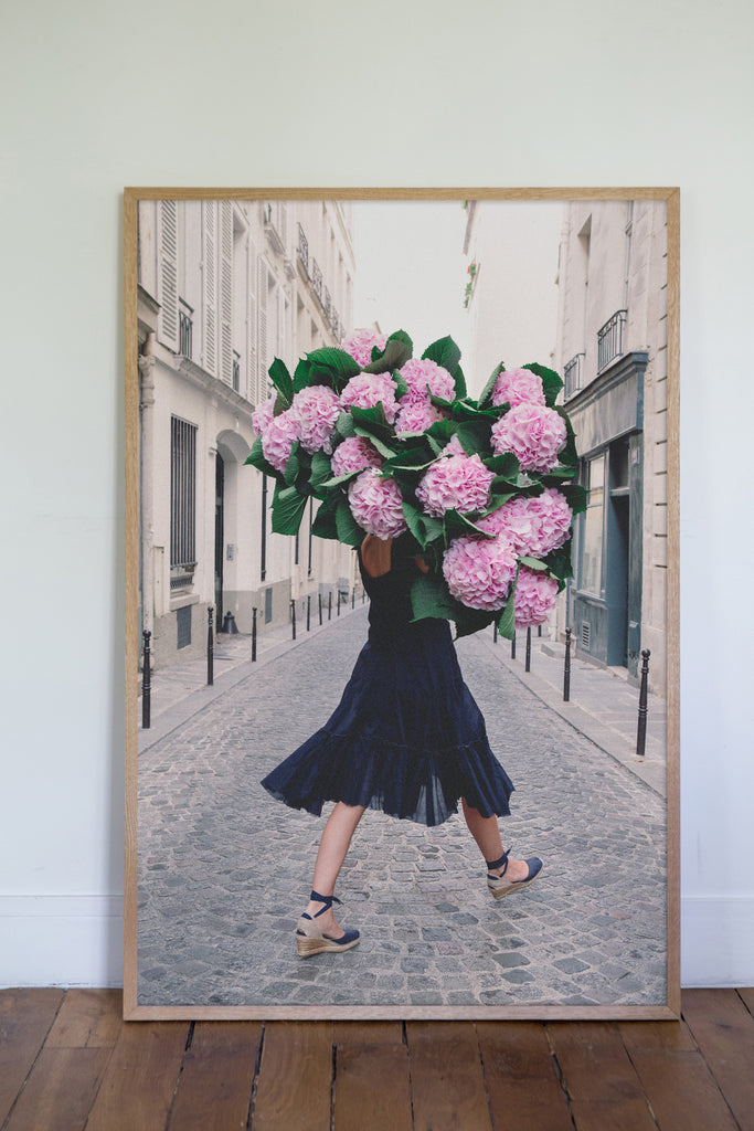 Free and Fearless is a photo of a girl in Paris in St Germain des Prés holding a giant bouquet of pink hydrangeas and is part of a limited edition series named Young Girl in Bloom by photographer Carla Coulson celebrating women loving and believing in themselves and building their self esteem by trusting their intuition.