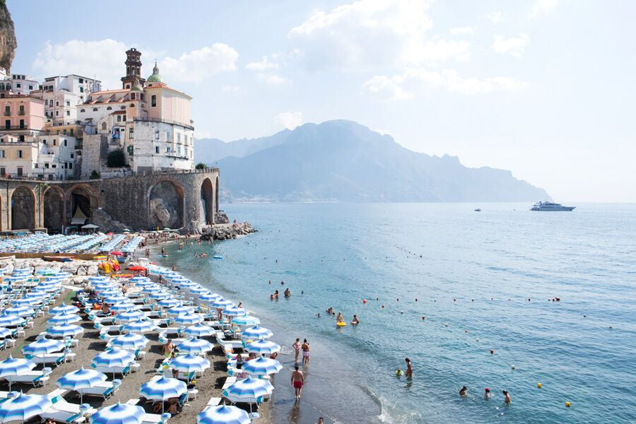 Blue and white beach umbrellas on Atrani beach the amalfi coast by Carla Coulson